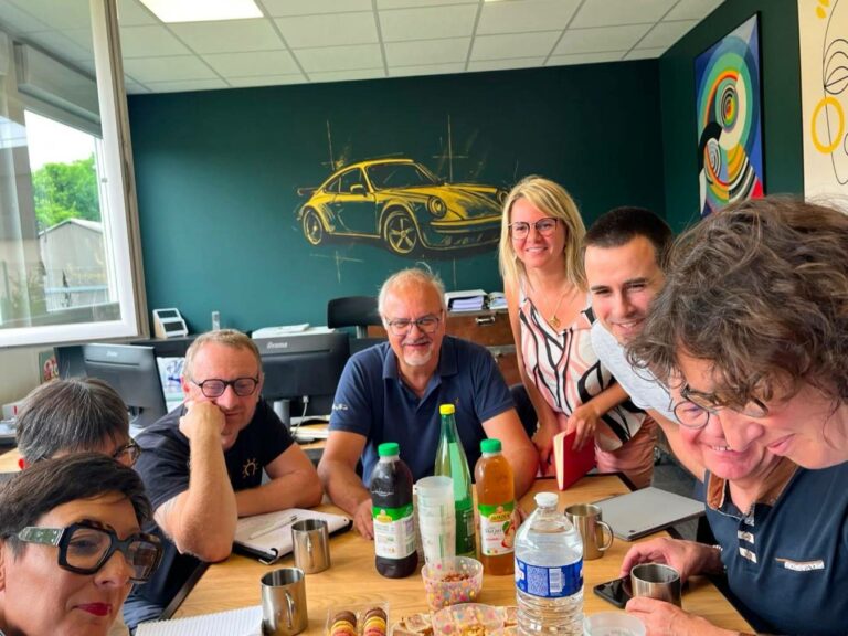 L'équipe PROFI réunie autour d'une table, souriante et engagée, symbolisant l'énergie collective et l'esprit d'équipe pour élaborer des stratégies financières performantes.